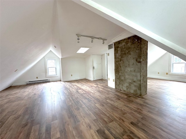 bonus room with visible vents, plenty of natural light, lofted ceiling with skylight, and a baseboard heating unit