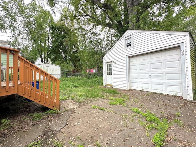 view of yard with an outbuilding, a garage, and driveway