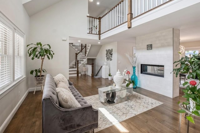 8 Hilltop Dr, Bayville, NY 11709 - living room featuring baseboards, wood finished floors, stairs, high vaulted ceiling, and a tile fireplace