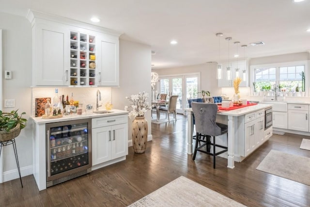 8 Hilltop Dr, Bayville, NY 11709 - bar with wet bar, recessed lighting, dark wood finished floors, beverage cooler, and a sink