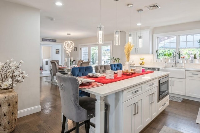 8 Hilltop Dr, Bayville, NY 11709 - kitchen with stainless steel microwave, recessed lighting, a center island, a breakfast bar area, and a sink