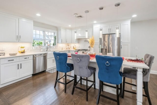 8 Hilltop Dr, Bayville, NY 11709 - kitchen with appliances with stainless steel finishes, dark wood finished floors, white cabinets, and a kitchen island