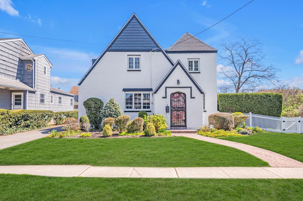 6 Howland Rd, East Rockaway, NY 11518 - tudor home featuring a gate, fence, and a front yard