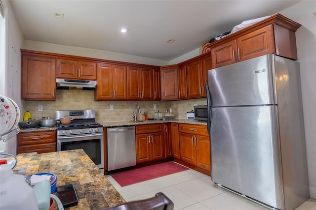 97-14 88th St, Ozone Park, NY 11416 - kitchen with light stone countertops, stainless steel appliances, under cabinet range hood, and backsplash