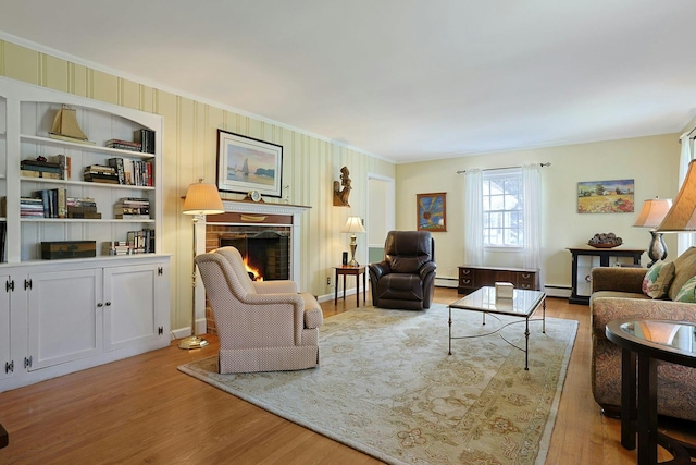 12 Heath Rd, Valhalla, NY 10595 - living room featuring a lit fireplace, ornamental molding, wood finished floors, and baseboard heating