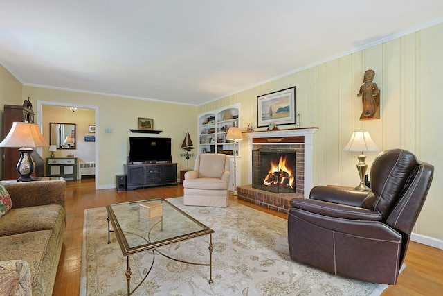 12 Heath Rd, Valhalla, NY 10595 - living room featuring radiator heating unit, wood finished floors, a fireplace, ornamental molding, and baseboards