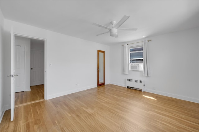 empty room with radiator, baseboards, ceiling fan, and light wood-type flooring