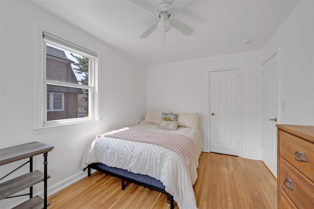 bedroom featuring ceiling fan, baseboards, and light wood-style flooring