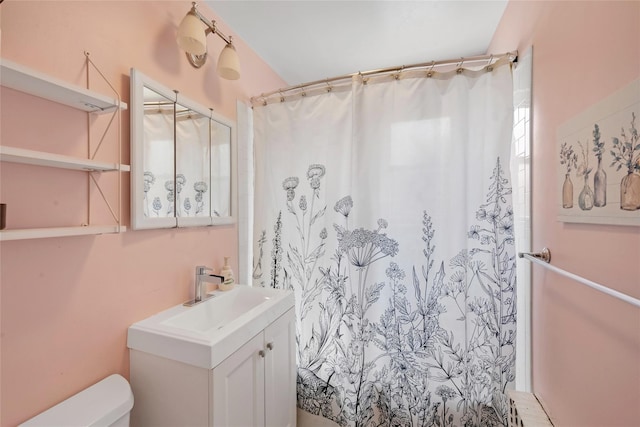 bathroom featuring toilet, vanity, and a shower with shower curtain