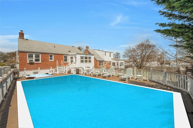 view of swimming pool with a fenced in pool, fence, and a deck