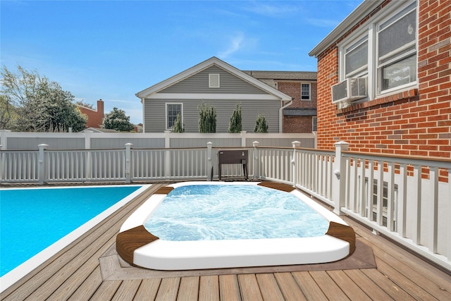 view of swimming pool featuring fence, hot tub deck surround, a deck, and cooling unit