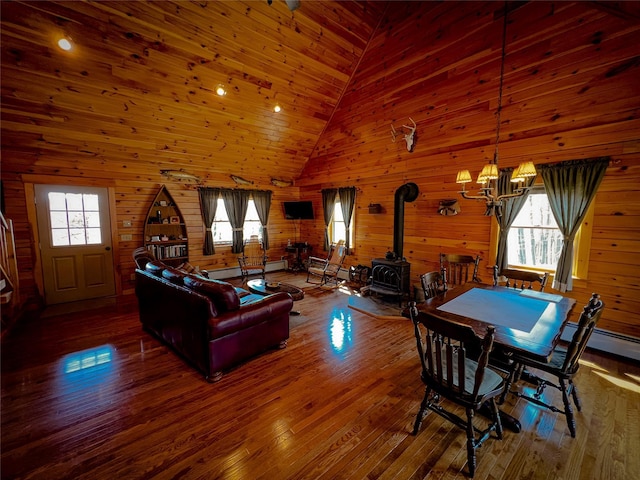 interior space with a wood stove, a notable chandelier, hardwood / wood-style flooring, and a healthy amount of sunlight