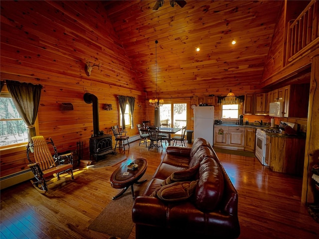 living area with high vaulted ceiling, a wood stove, wood-type flooring, and wooden ceiling