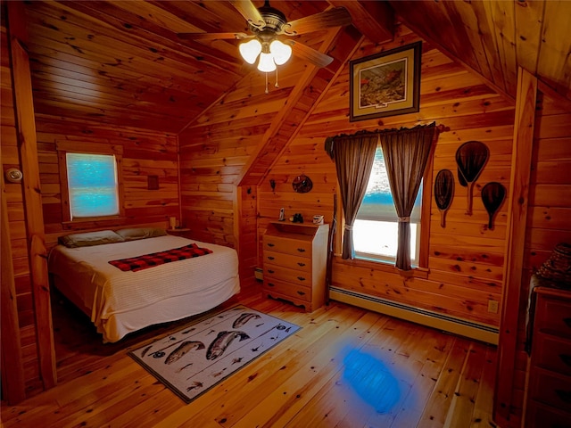 bedroom with a baseboard radiator, wood walls, vaulted ceiling, and light wood-style floors