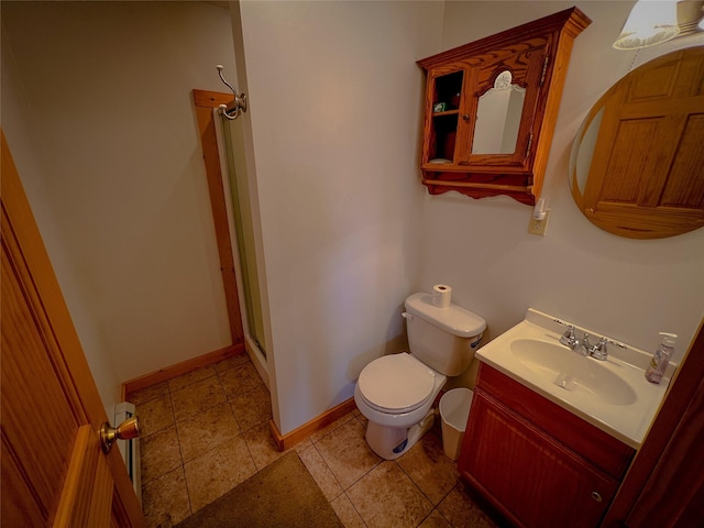 bathroom featuring a shower stall, vanity, baseboards, and toilet