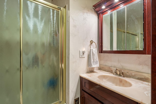 bathroom featuring vanity, a shower stall, and a textured wall