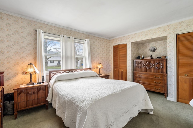 bedroom with wallpapered walls, crown molding, carpet, and two closets