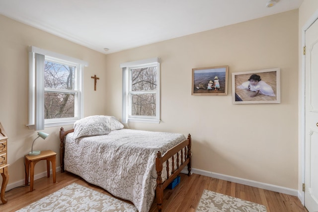 bedroom featuring wood finished floors and baseboards