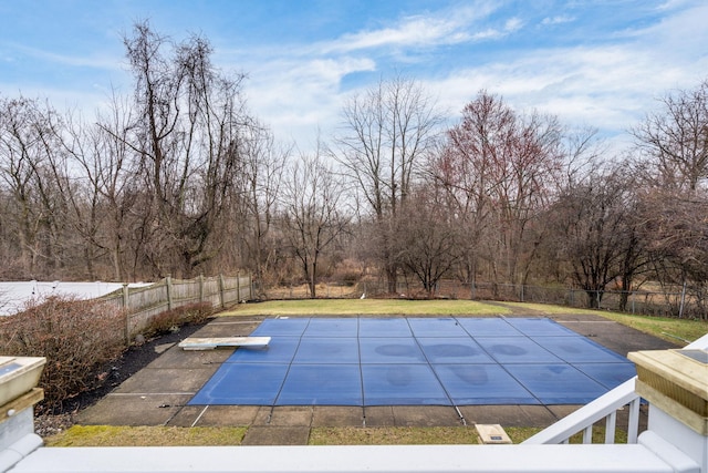 view of swimming pool with a diving board, a fenced backyard, and a fenced in pool