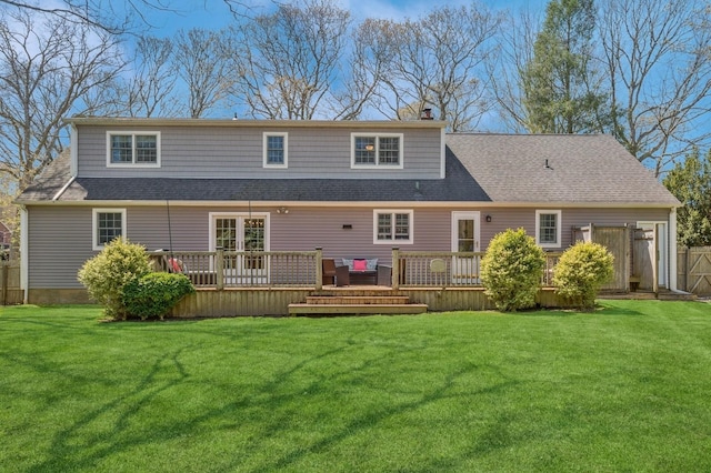 rear view of property featuring fence, a wooden deck, and a yard