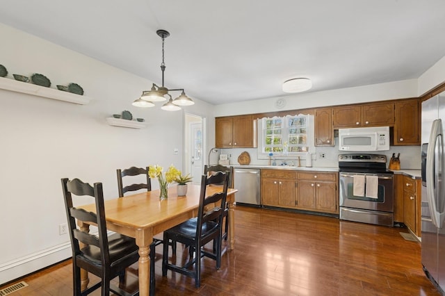 dining space with a chandelier, visible vents, and dark wood-type flooring