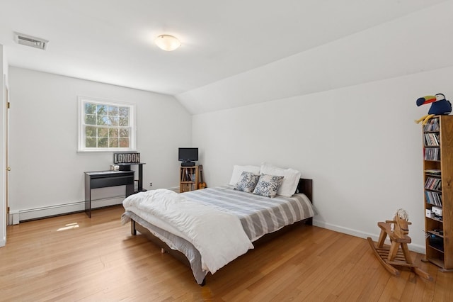 bedroom with visible vents, light wood finished floors, baseboards, lofted ceiling, and a baseboard heating unit