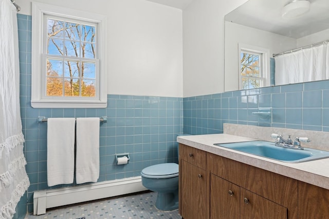 bathroom featuring vanity, toilet, a wainscoted wall, tile walls, and a baseboard radiator