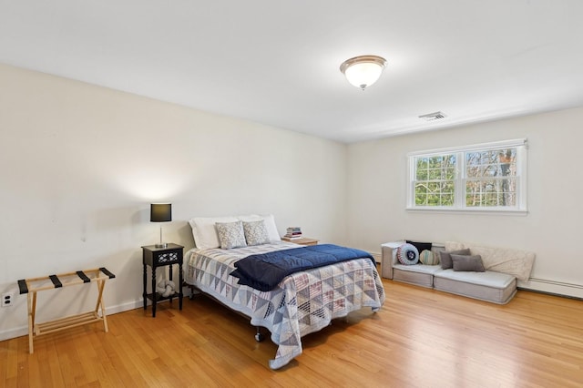 bedroom featuring visible vents and wood finished floors