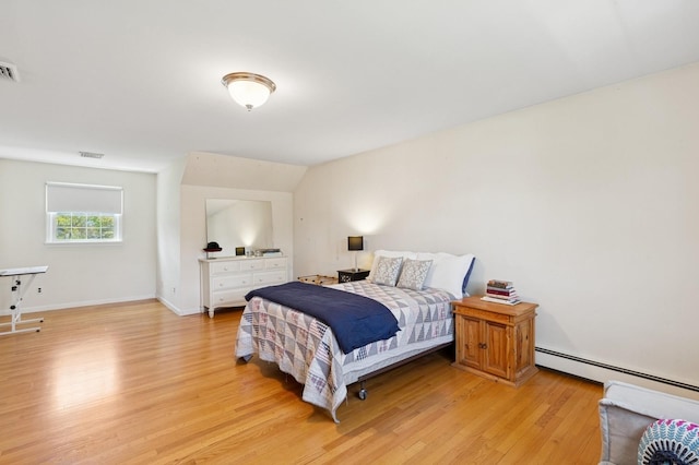 bedroom featuring baseboards, visible vents, baseboard heating, and light wood-style floors