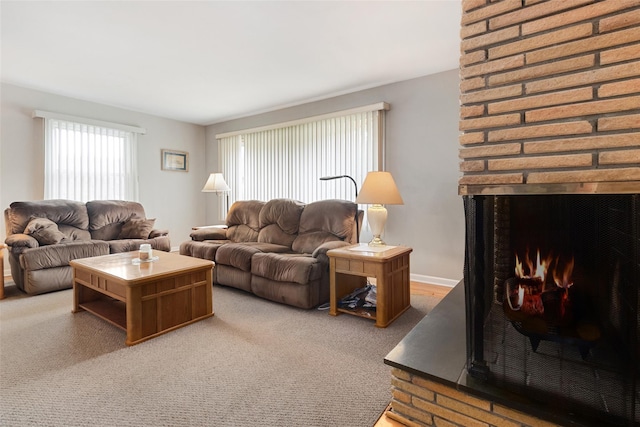 carpeted living room featuring a multi sided fireplace, baseboards, and plenty of natural light