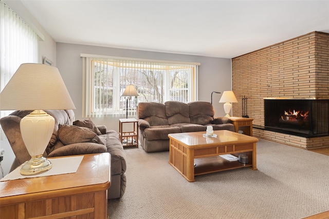 living room featuring light carpet, a fireplace, and a healthy amount of sunlight