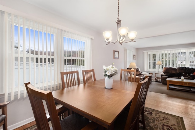dining space with an inviting chandelier and wood finished floors