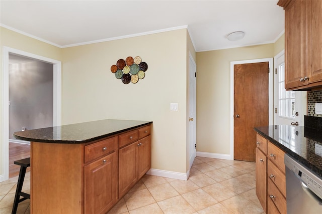 kitchen featuring baseboards, dishwasher, a kitchen bar, and ornamental molding