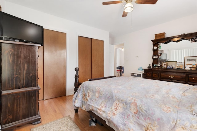 bedroom with light wood-style floors, two closets, and ceiling fan