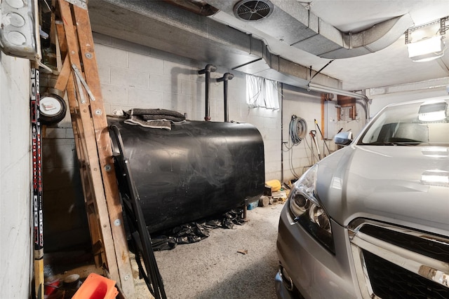 garage with visible vents, concrete block wall, and heating fuel