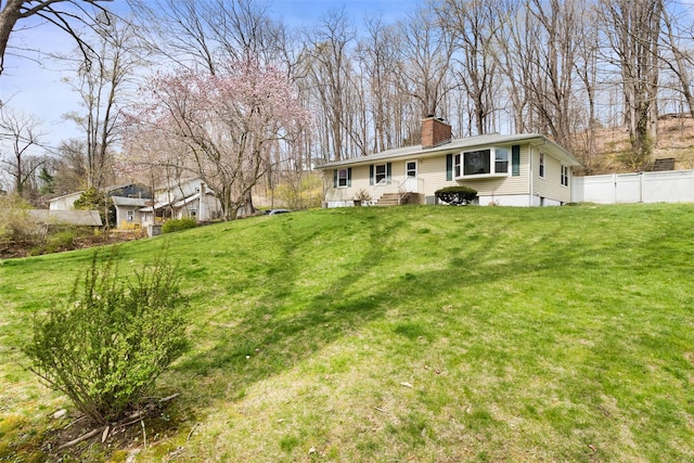 exterior space featuring a chimney, a front yard, and fence