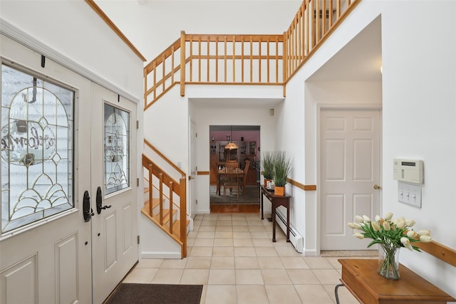 13 Cross Rd, Cortlandt Manor, NY 10567 - entryway featuring baseboard heating, a high ceiling, light tile patterned flooring, stairs, and baseboards