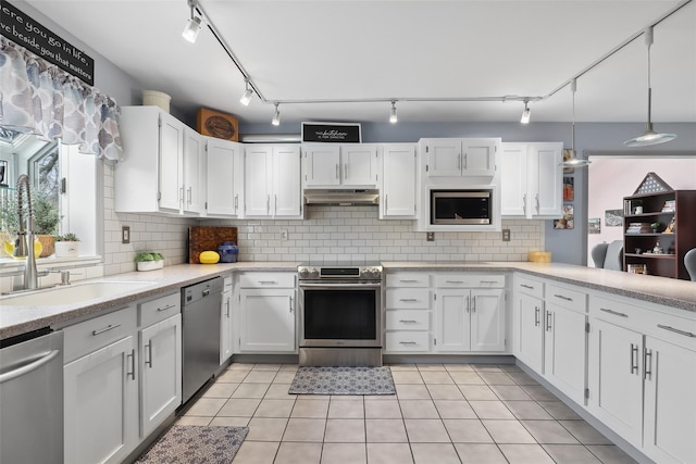 13 Cross Rd, Cortlandt Manor, NY 10567 - kitchen with stainless steel appliances, under cabinet range hood, white cabinetry, and track lighting