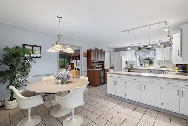 13 Cross Rd, Cortlandt Manor, NY 10567 - kitchen with light countertops, white fridge with ice dispenser, white cabinetry, decorative backsplash, and wine cooler
