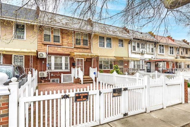 3518 Clarendon Rd, Brooklyn, NY 11203 - view of front facade featuring a gate, brick siding, ac unit, and a fenced front yard