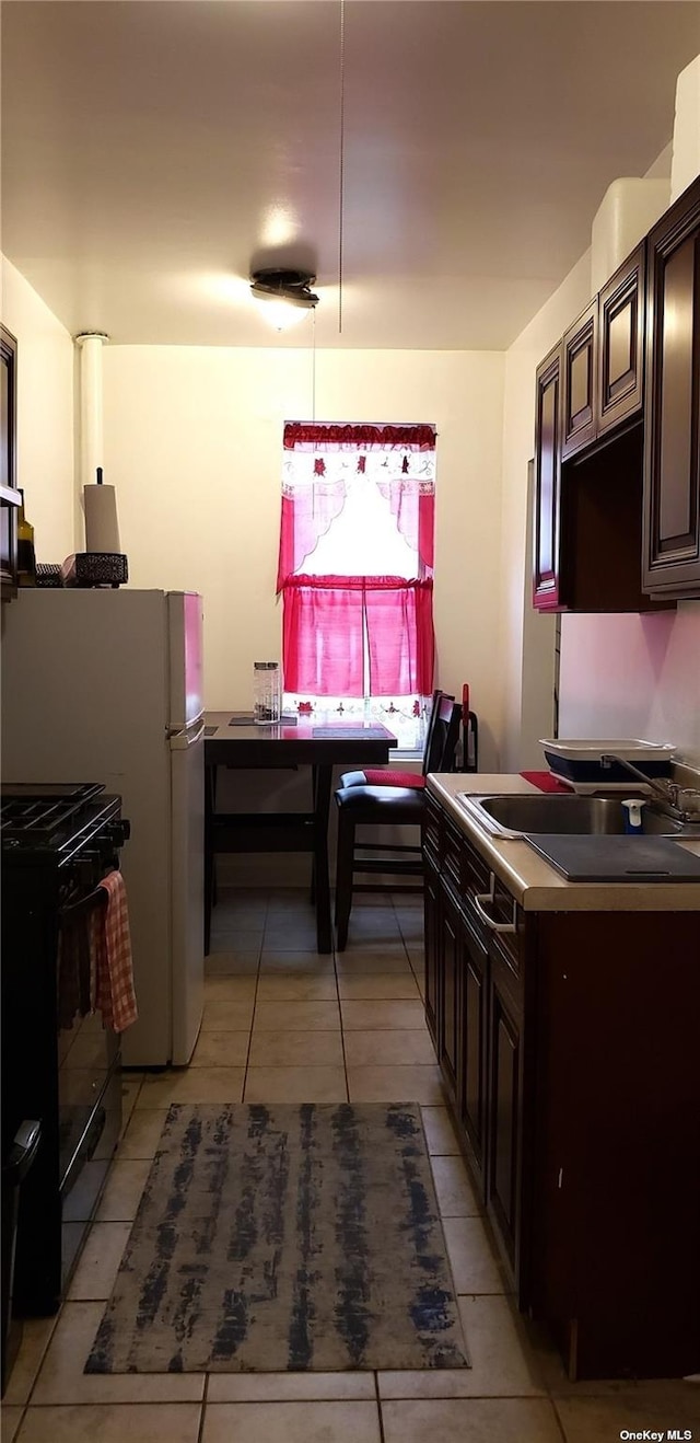 44-15 43rd Ave Unit 5N, Sunnyside, NY 11104 - kitchen featuring dark countertops, light tile patterned floors, black gas range, and dark brown cabinetry