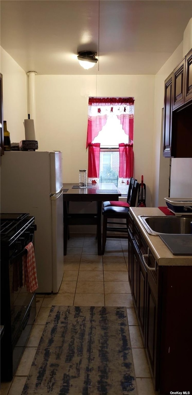 44-15 43rd Ave Unit 5N, Sunnyside, NY 11104 - kitchen featuring black range with electric stovetop, light tile patterned floors, a sink, and dark brown cabinetry