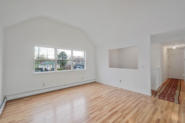 empty room with baseboard heating, a baseboard radiator, wood finished floors, and lofted ceiling