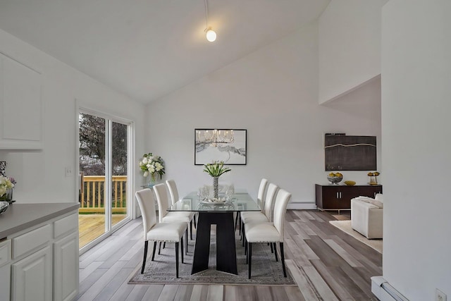 dining area featuring high vaulted ceiling, baseboard heating, a baseboard radiator, and wood finished floors