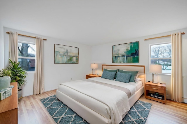 bedroom featuring multiple windows and light wood finished floors