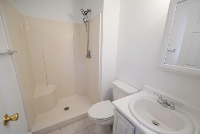 bathroom with toilet, a stall shower, vanity, and tile patterned floors