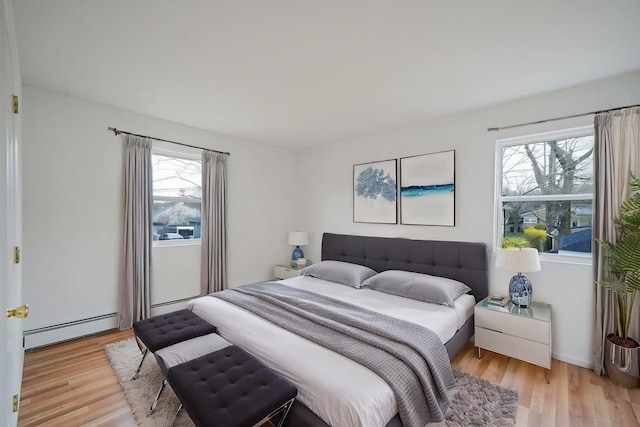 bedroom featuring baseboard heating and light wood-type flooring