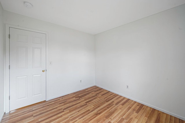 spare room featuring light wood-style flooring and baseboards