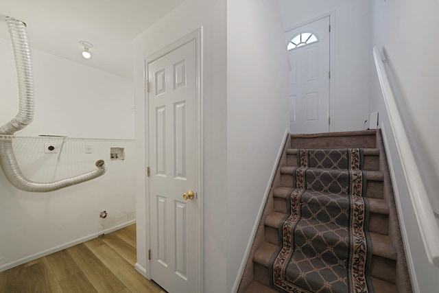 staircase with baseboards and wood finished floors