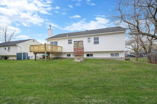 rear view of house with a yard, fence, a deck, and a chimney
